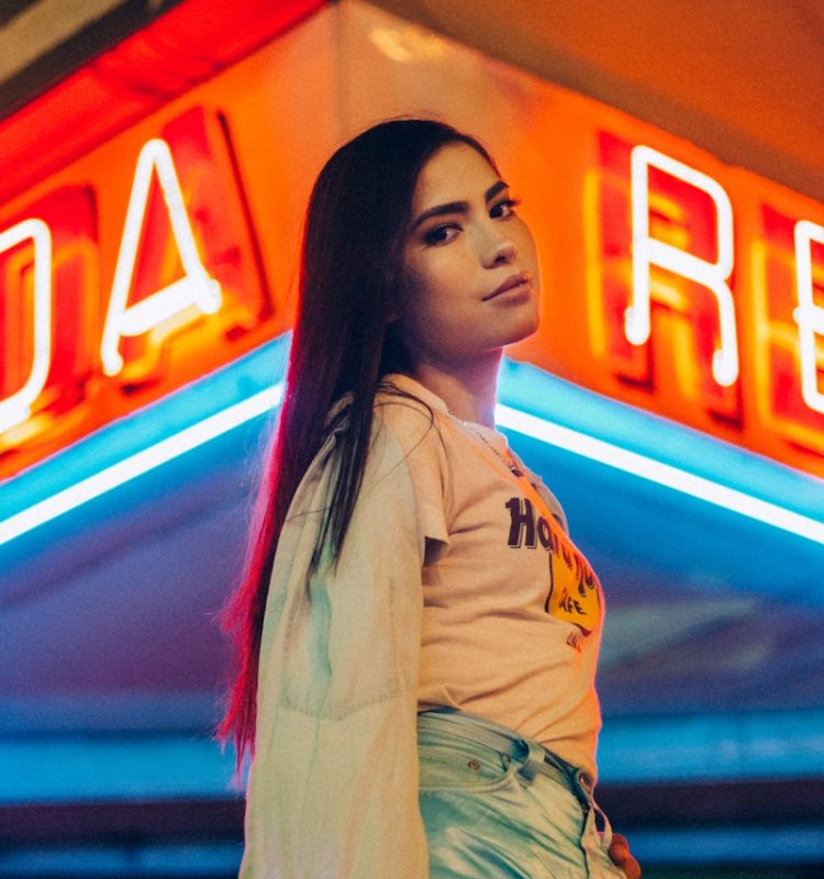 woman standing near red neon light signages